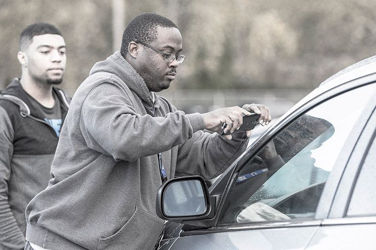 Two people inspecting car with the new mobile app